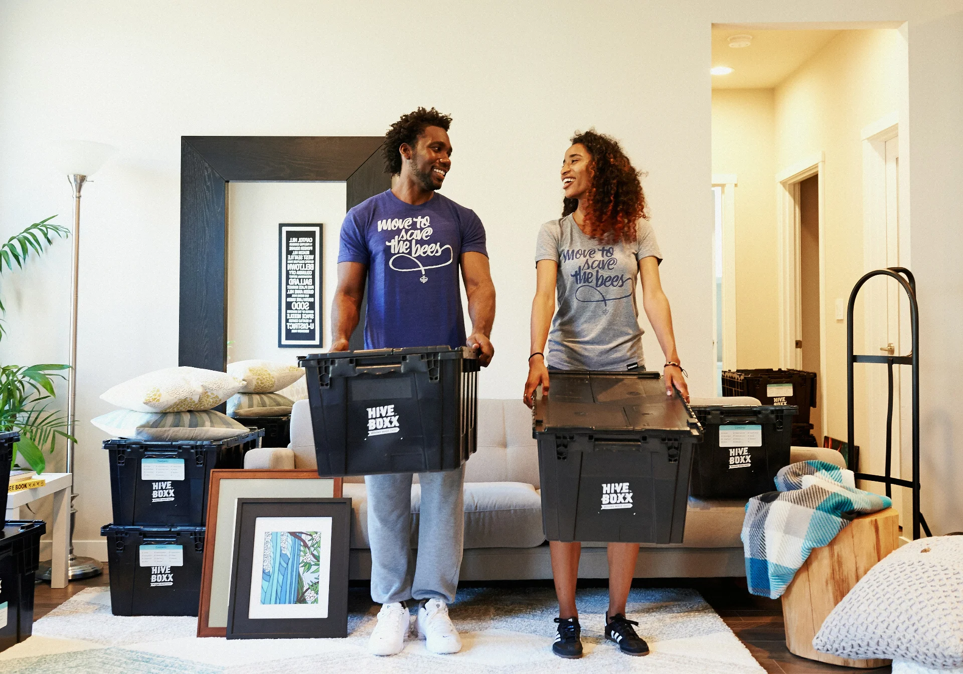 Couple carrying moving boxes into their new home