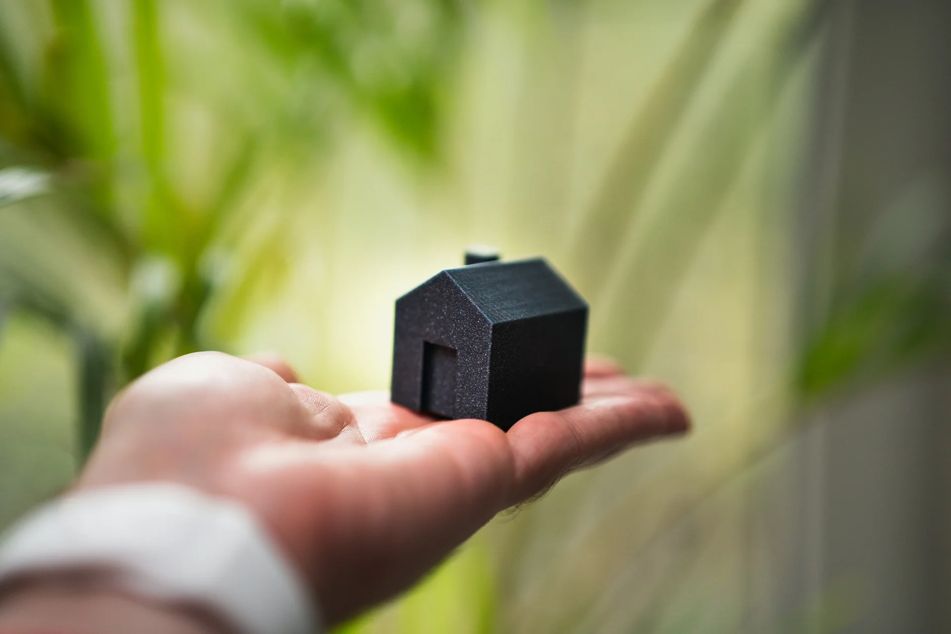 Hand holding a miniature house representing mortgage protection