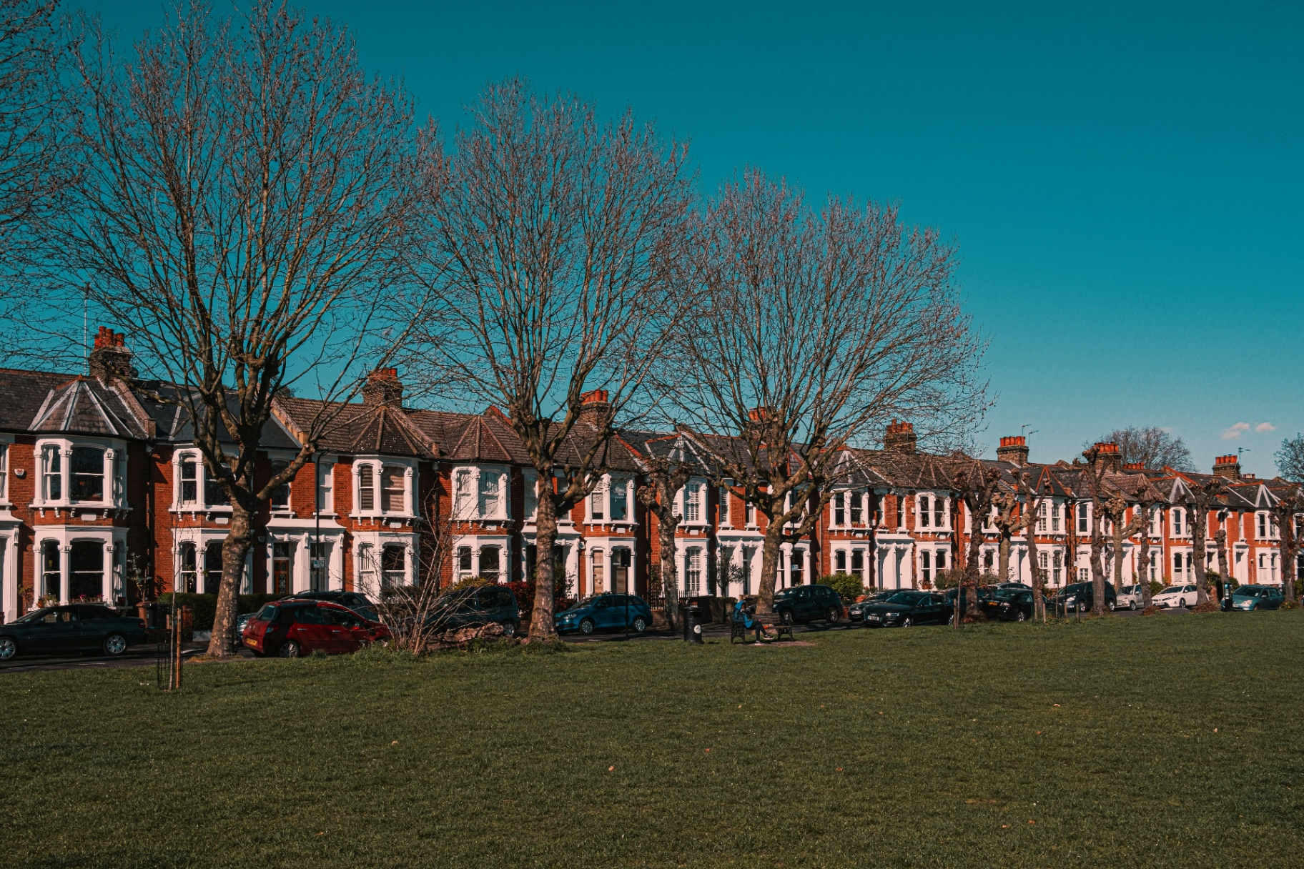 View of British terraced houses across a green park