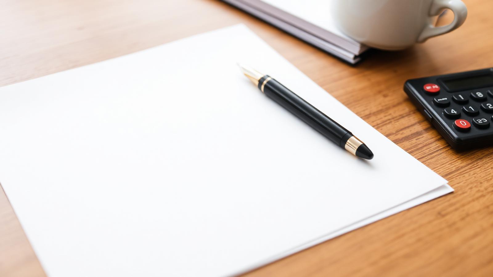 Desk with paperwork, a pen and a calculator ready for a mortgage application